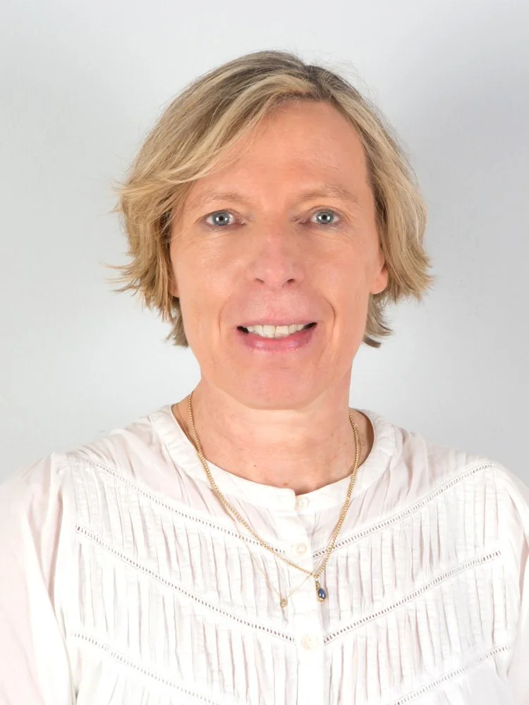 Porträt einer Frau mit kurzen, blonden Haaren vor hellem Hintergrund