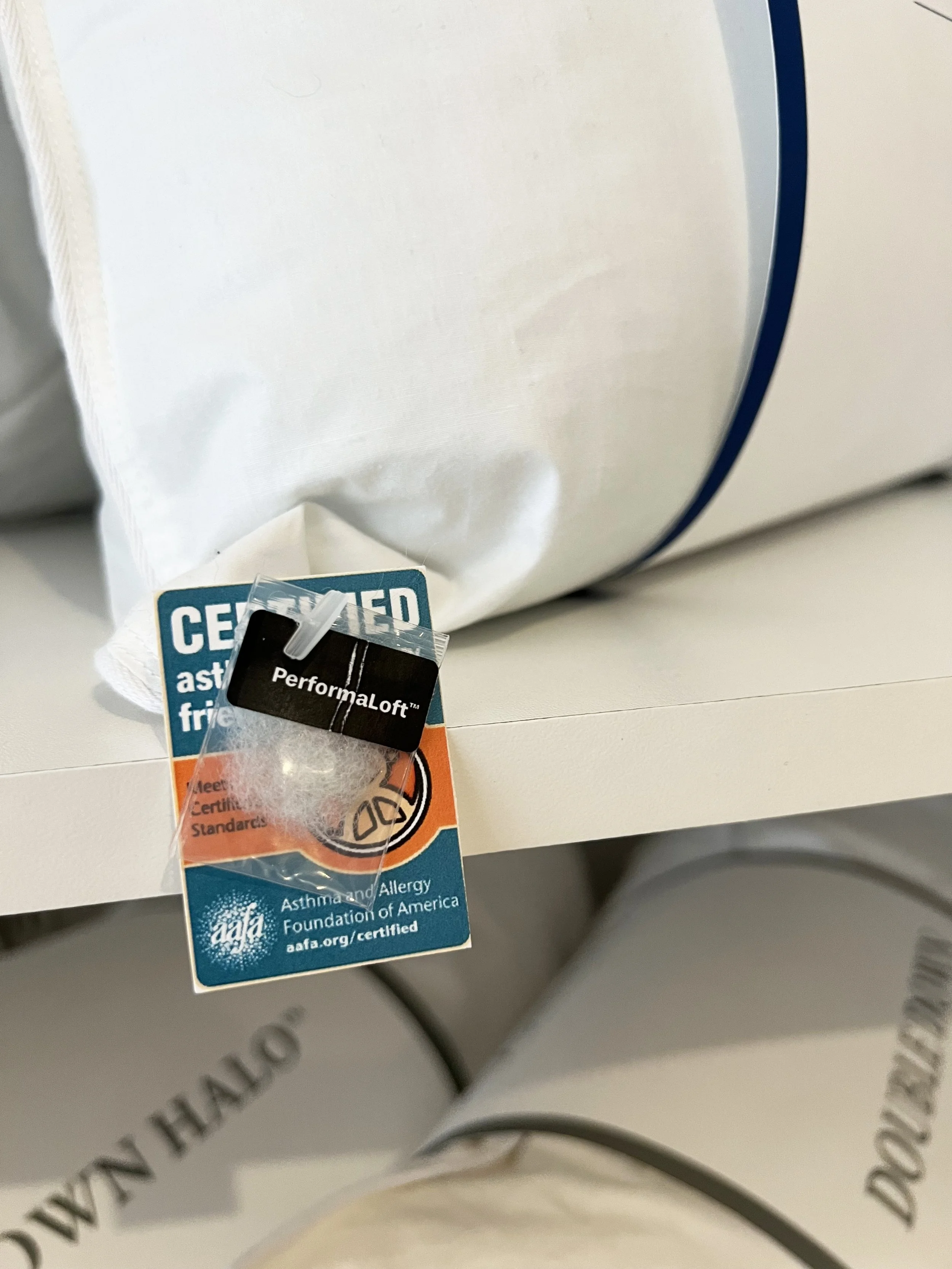Pillows of polyester fill were displayed at the NYC Home Textiles Market.  Attached small baggies showed what the inner fill actually looked like, as well as how it was certified.