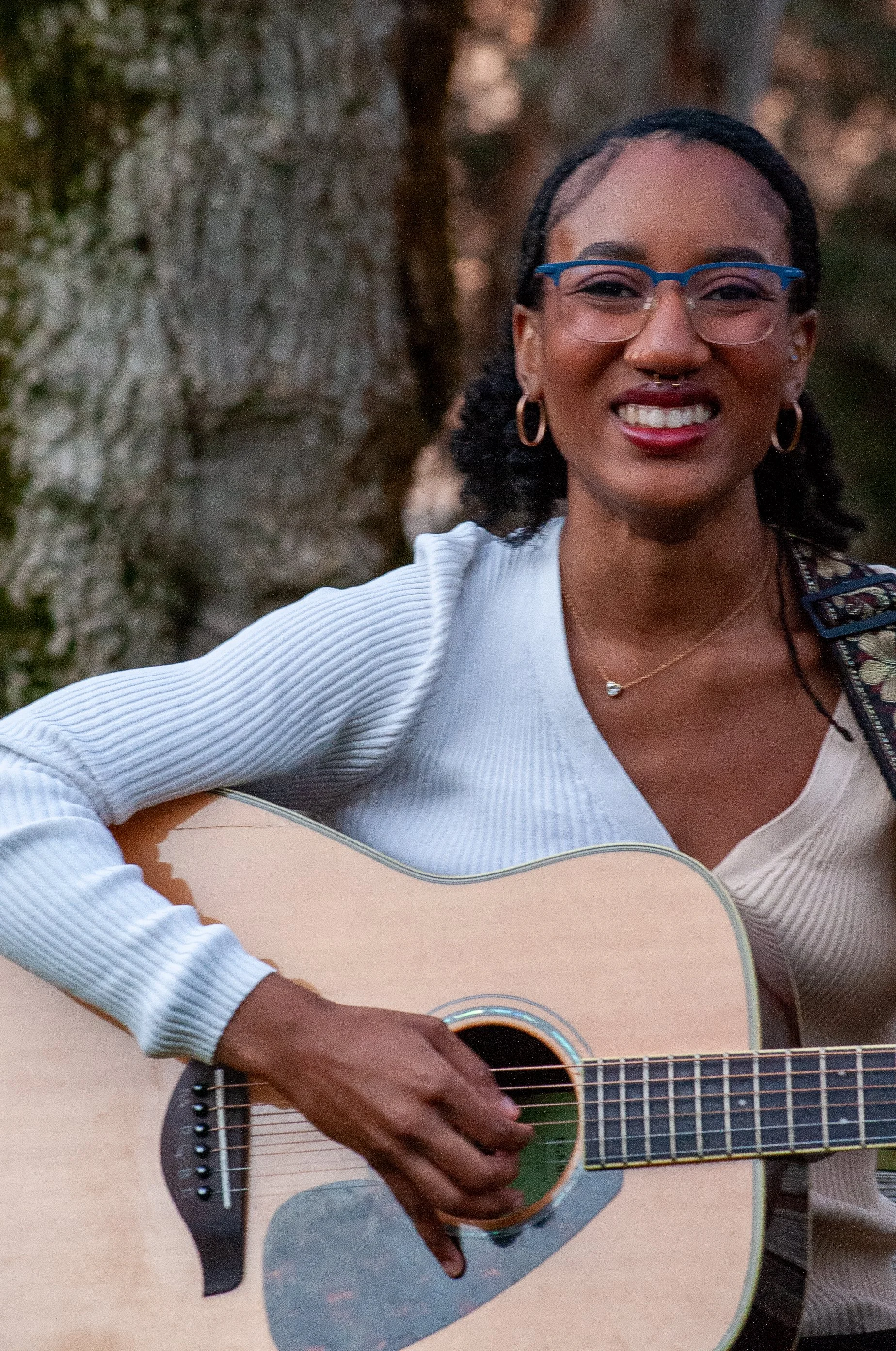 black woman with guitar grinning