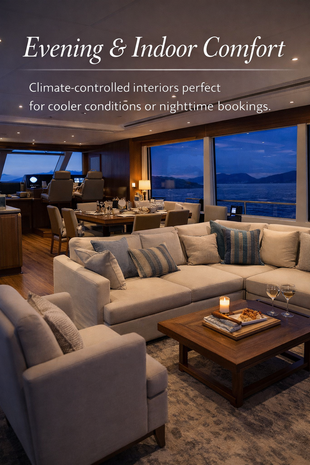 Elegant living room and dining area on a cruise ship with a view of the ocean and mountains through large windows, candlelit table with wine glasses and snacks, cozy cushions on sofas, warm lighting, and a relaxed evening atmosphere.