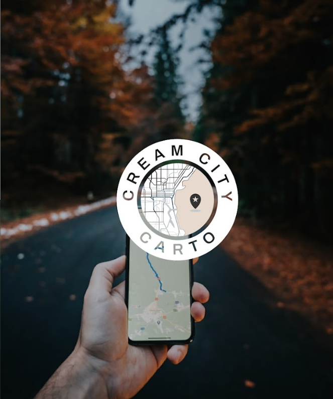 Person holding a smartphone with a map app open, standing on a forested road with autumn leaves, and a logo overlay for 'Cream City Carto' featuring a map and a star icon.