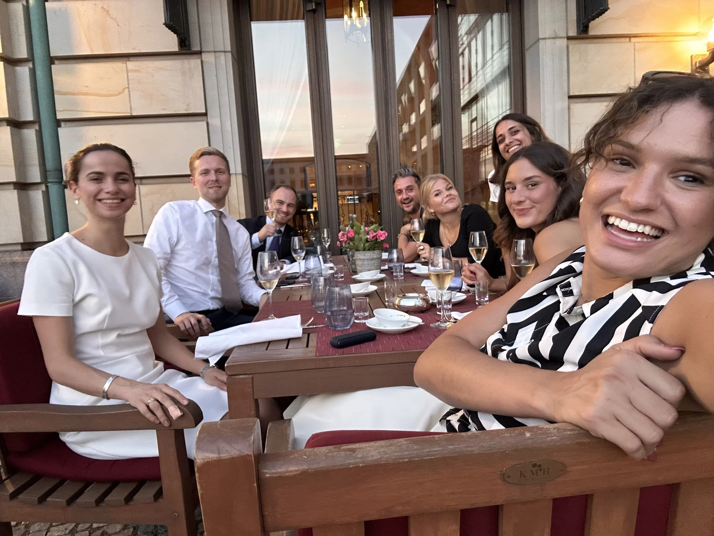 Eine Gruppe von acht Menschen sitzt draußen vor dem Hotel Adlon Kempinski, Sales und Projektmanagement kommt zusammen und wir besprechen die Partnerschaft des kommenden Jahres