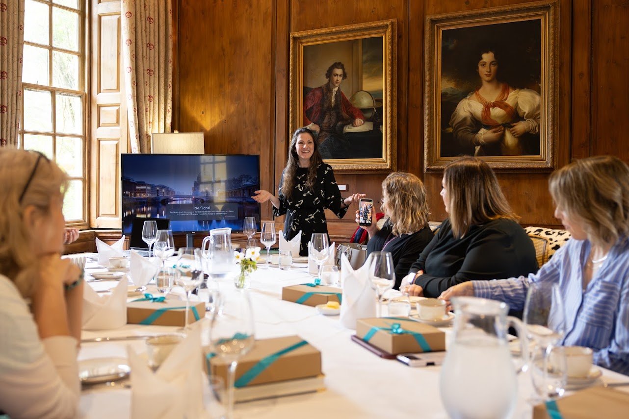 Martina, founder of The Success Circle standing at a table of women at Hintlesham Hall