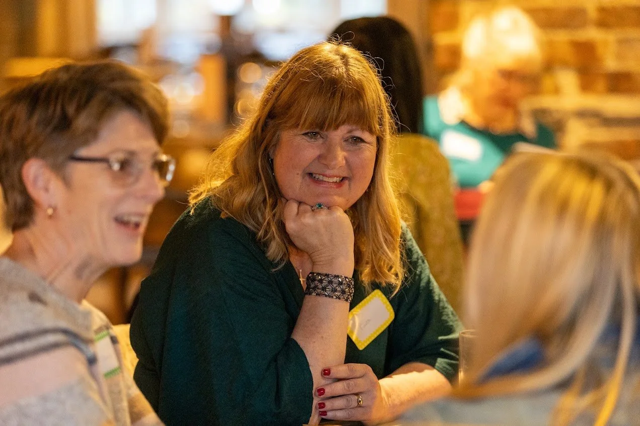ruth sitting at a table with other women having a relaxed conversation at Ego The Seal In Woodbridge all smiling and laughing