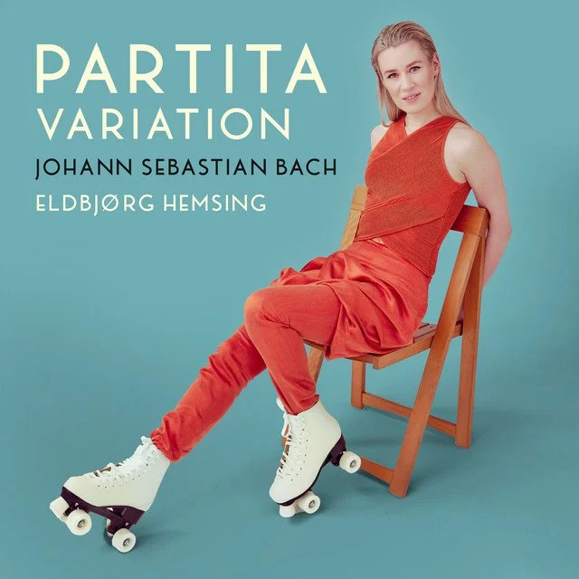 Cover art for a music album featuring a young woman wearing orange pants, a sleeveless orange top, and white roller skates, sitting on a wooden chair against a teal background. Text on the image reads: 'Partita Variation by Johann Sebastian Bach, Eldbjørg Hemsing.'