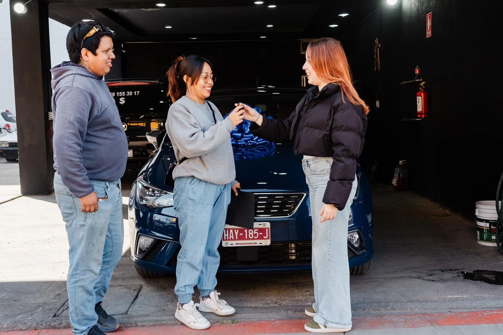 asesora entregándole el vehículo seminuevo y clientes contentos 