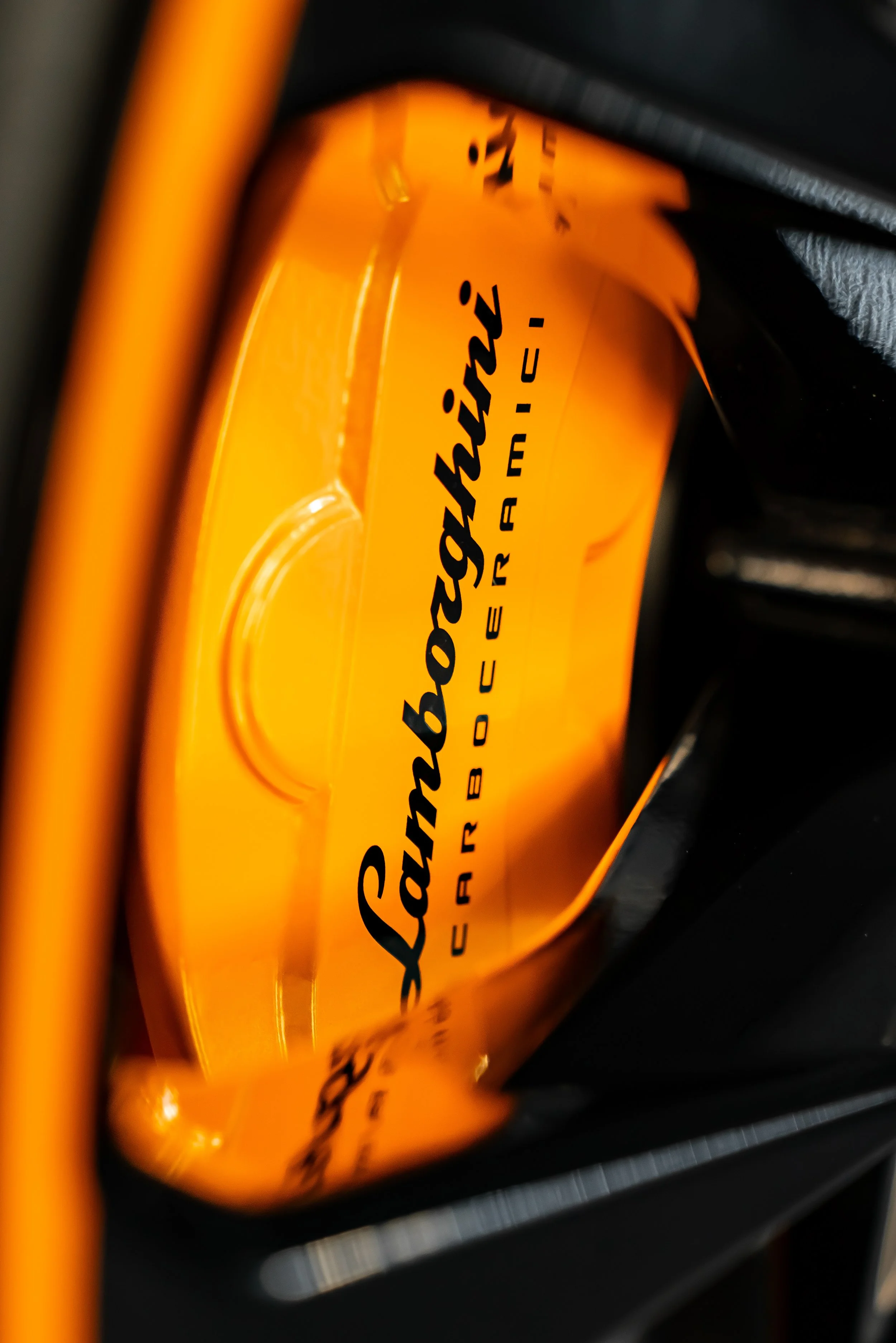 Orange Lamborghini caliper that was sent out for powder coating.