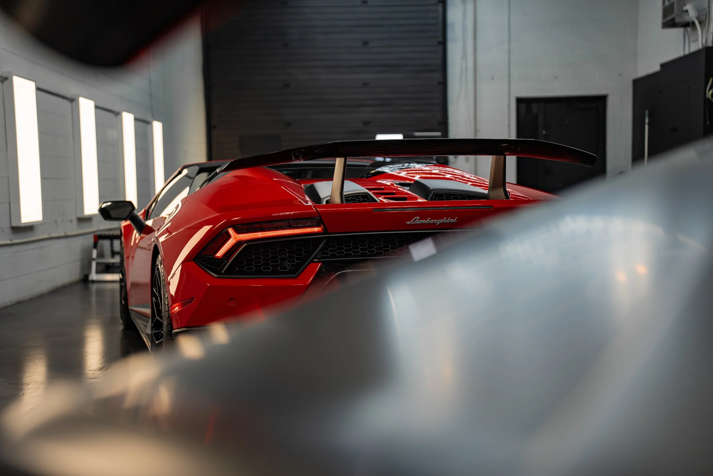 The back end of a Lamborghini Huracan Performante exposing the forged carbon fibre spoiler