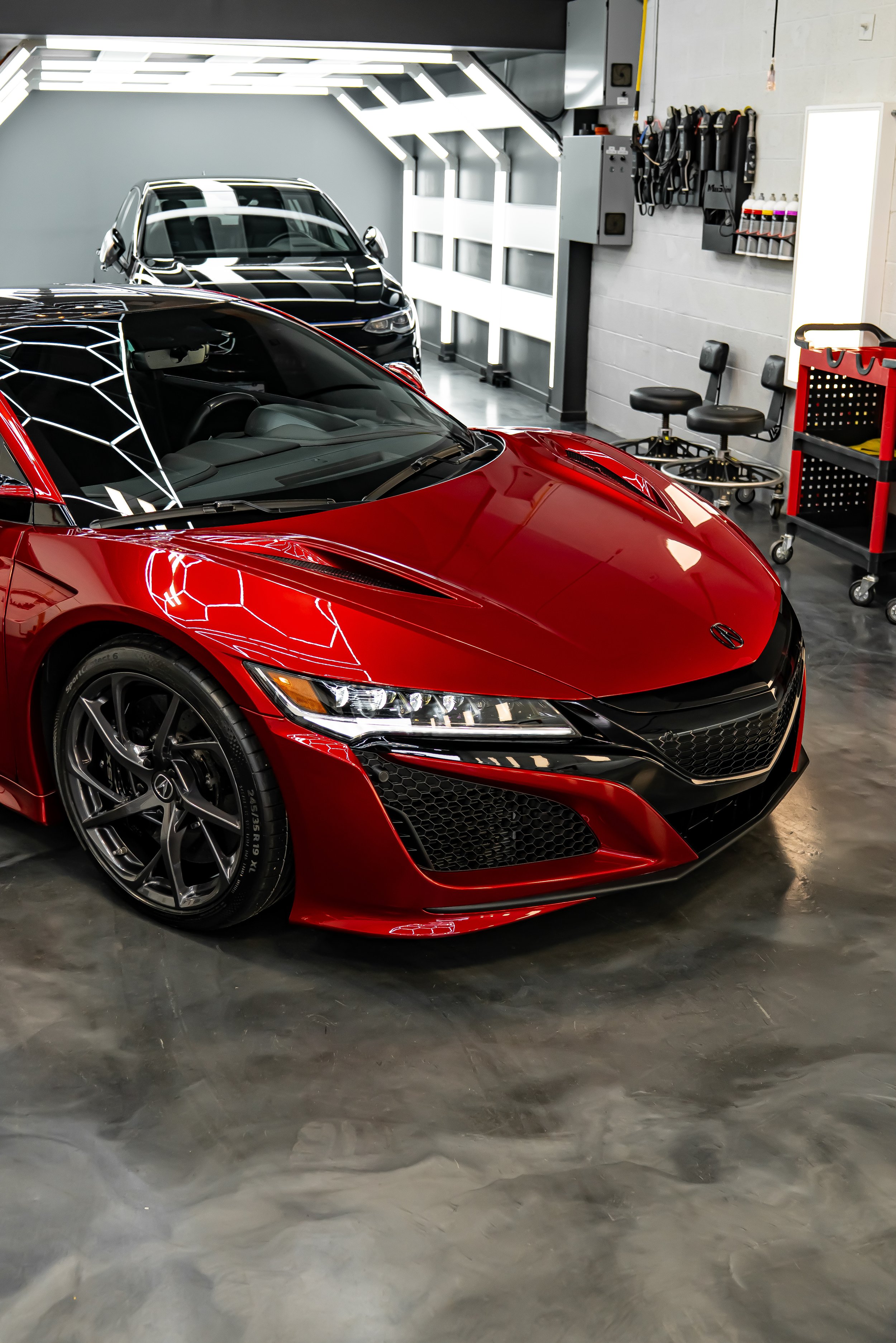 Luxury red Acura NSX supercar receiving professional detailing inside ZAutoCare’s high-end auto detailing studio, featuring glossy paint correction, ceramic coating, PPF and premium vehicle care environment with LED lighting reflections and clean wor