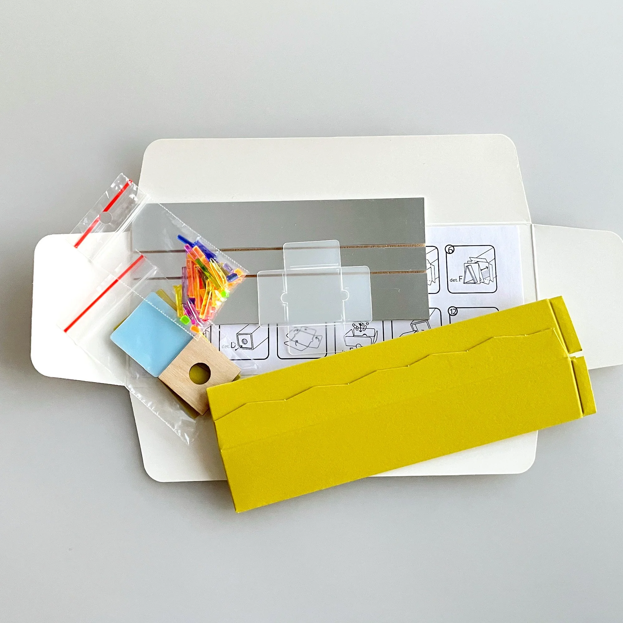 DIY paper kaleidoscope kit components showing mirrors and colorful accessories.