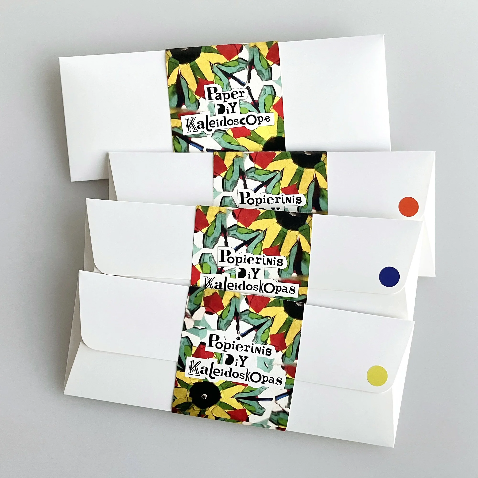 Handmade paper kaleidoscope DIY kits in minimal white packaging.