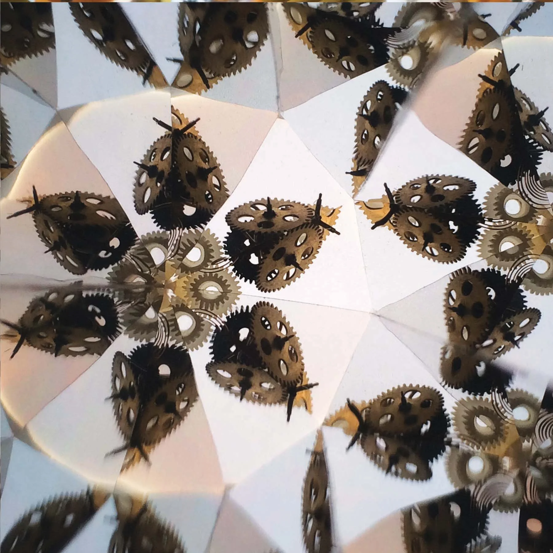 Kaleidoscope pattern of mechanical clock gears and bronze cogs.