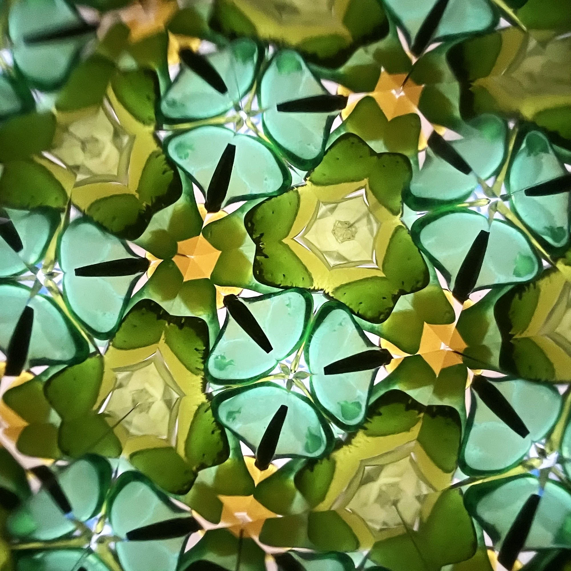  Intricate mint and forest green kaleidoscope pattern with geometric star shapes and amber highlights. 
