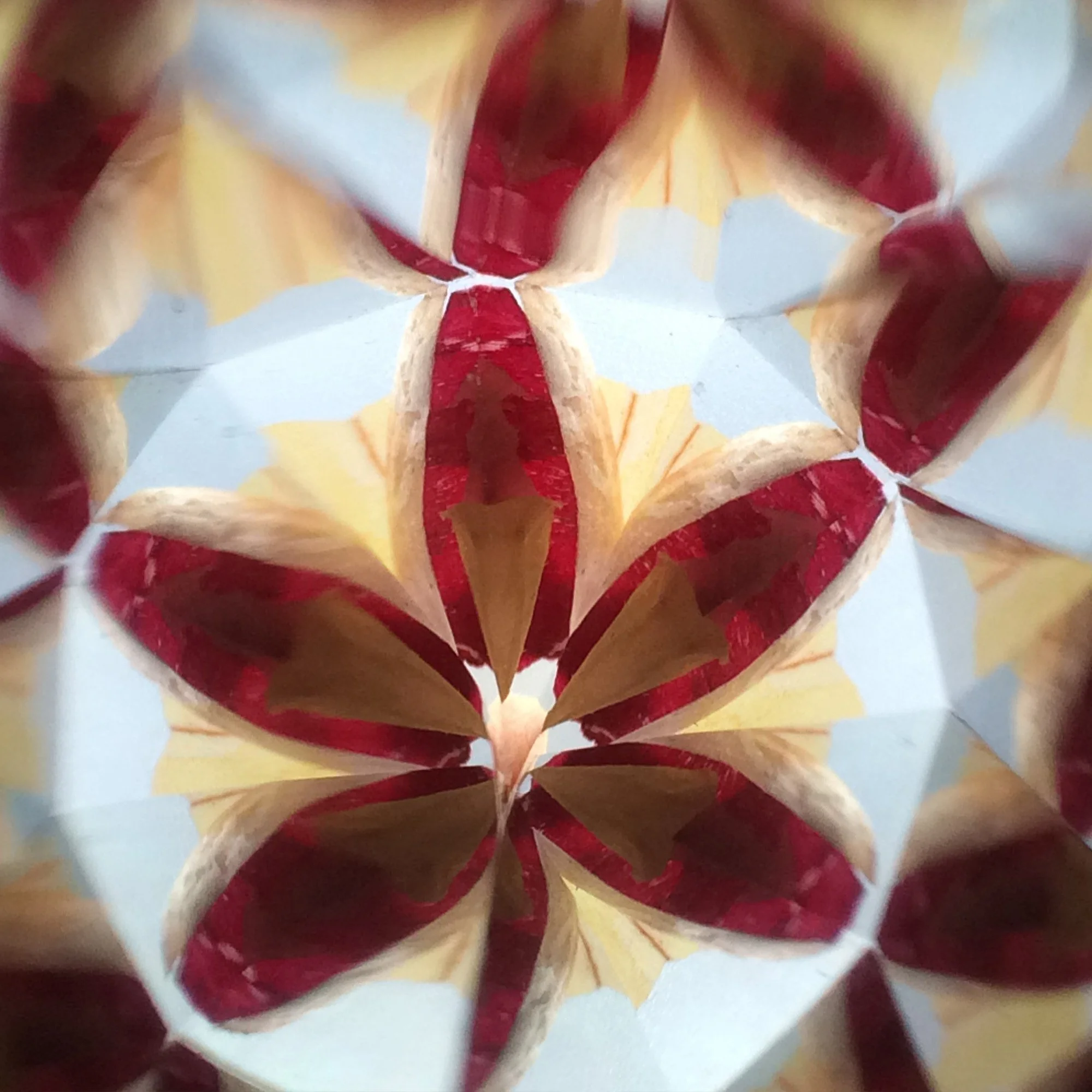  Symmetrical kaleidoscope pattern in deep burgundy and gold, resembling a blooming spring flower, inspired by onion skin dyeing. 