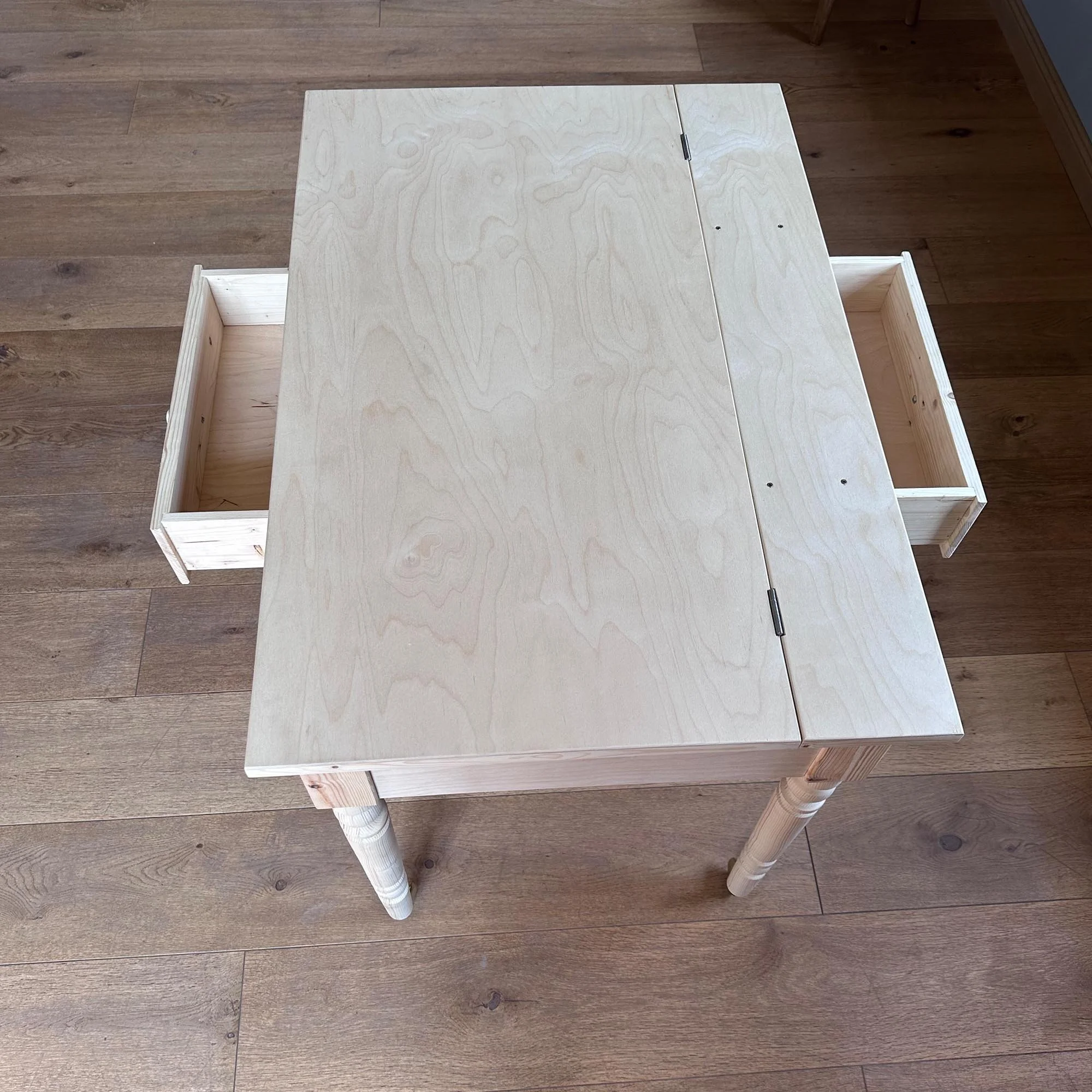  Top-down view of the desk with plywood tabletop and two side drawers partially extended. 