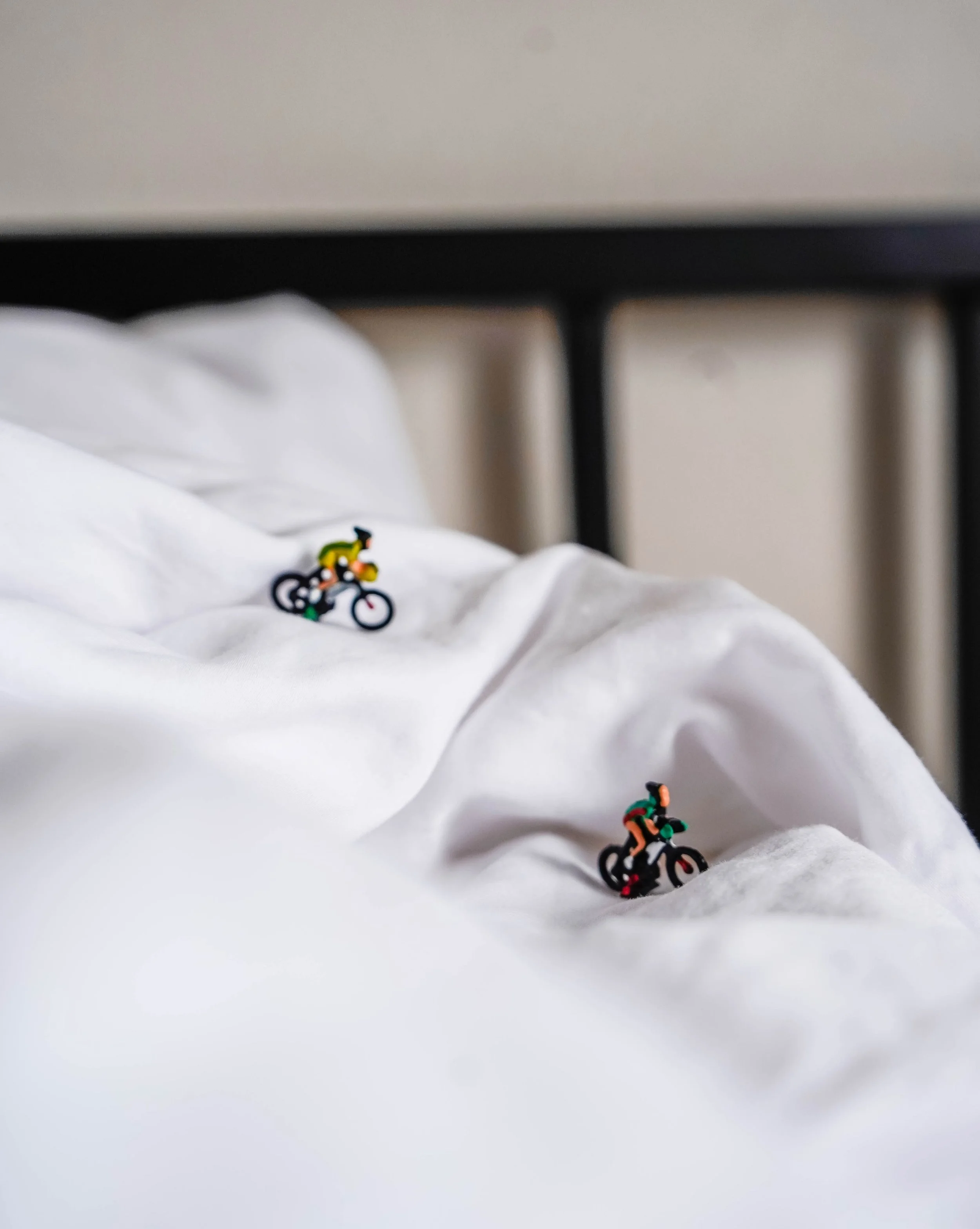 Biker figurines over white hotel sheets