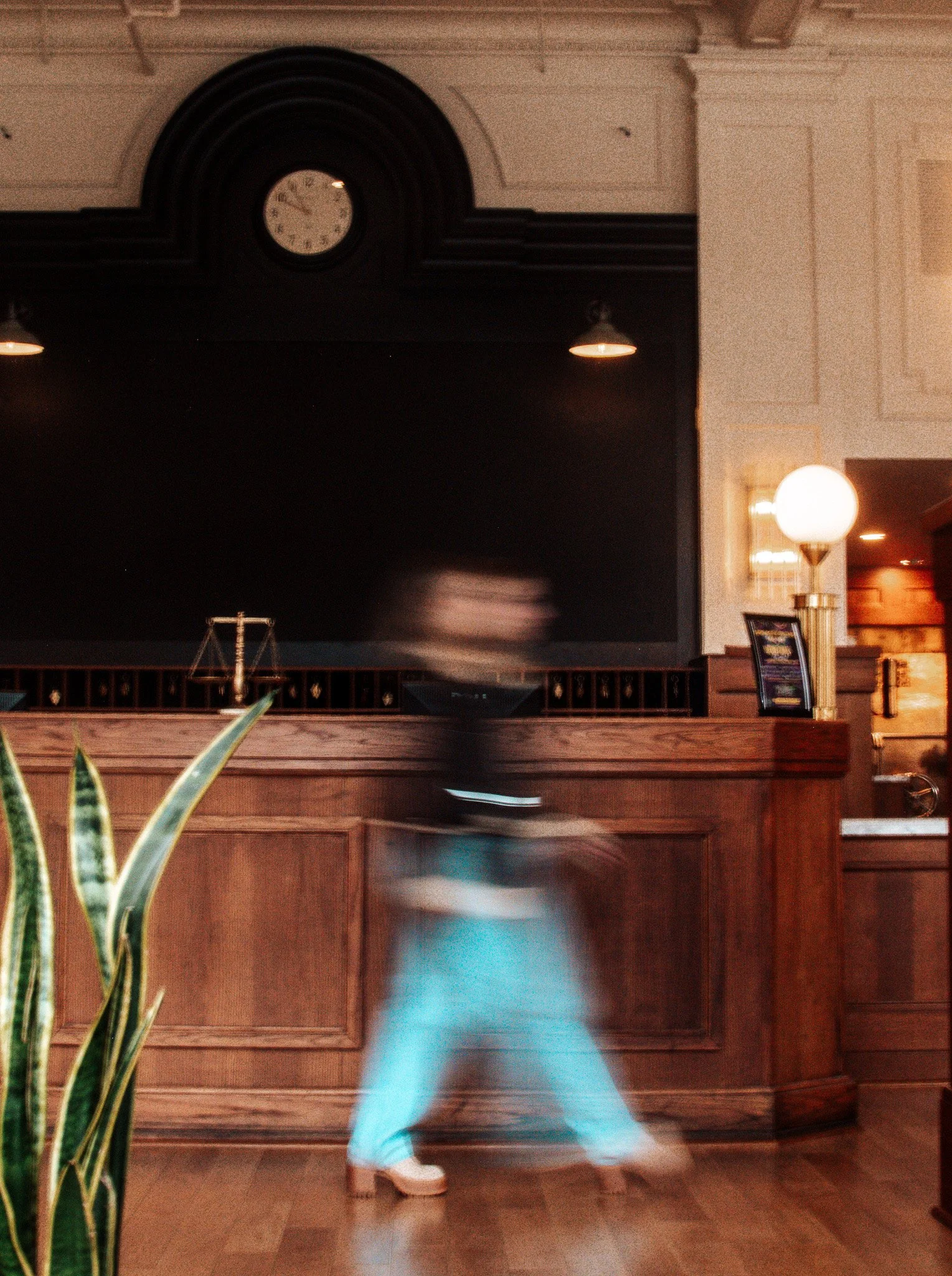 A blurry figure walks through a hotel lobby