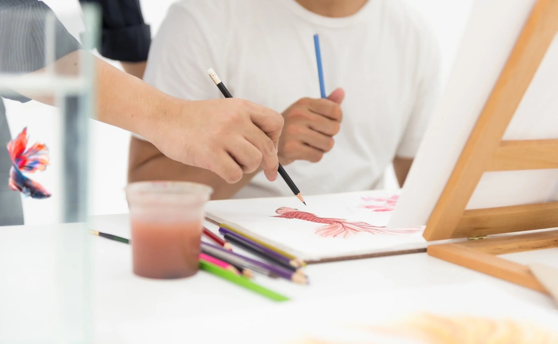 Student sketching and painting during an art class.