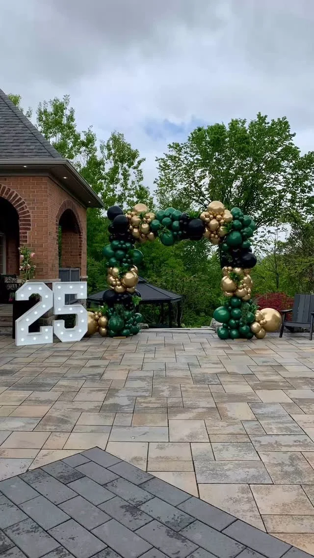 Prom  Outdoor balloon arch Green, black, and gold balloons