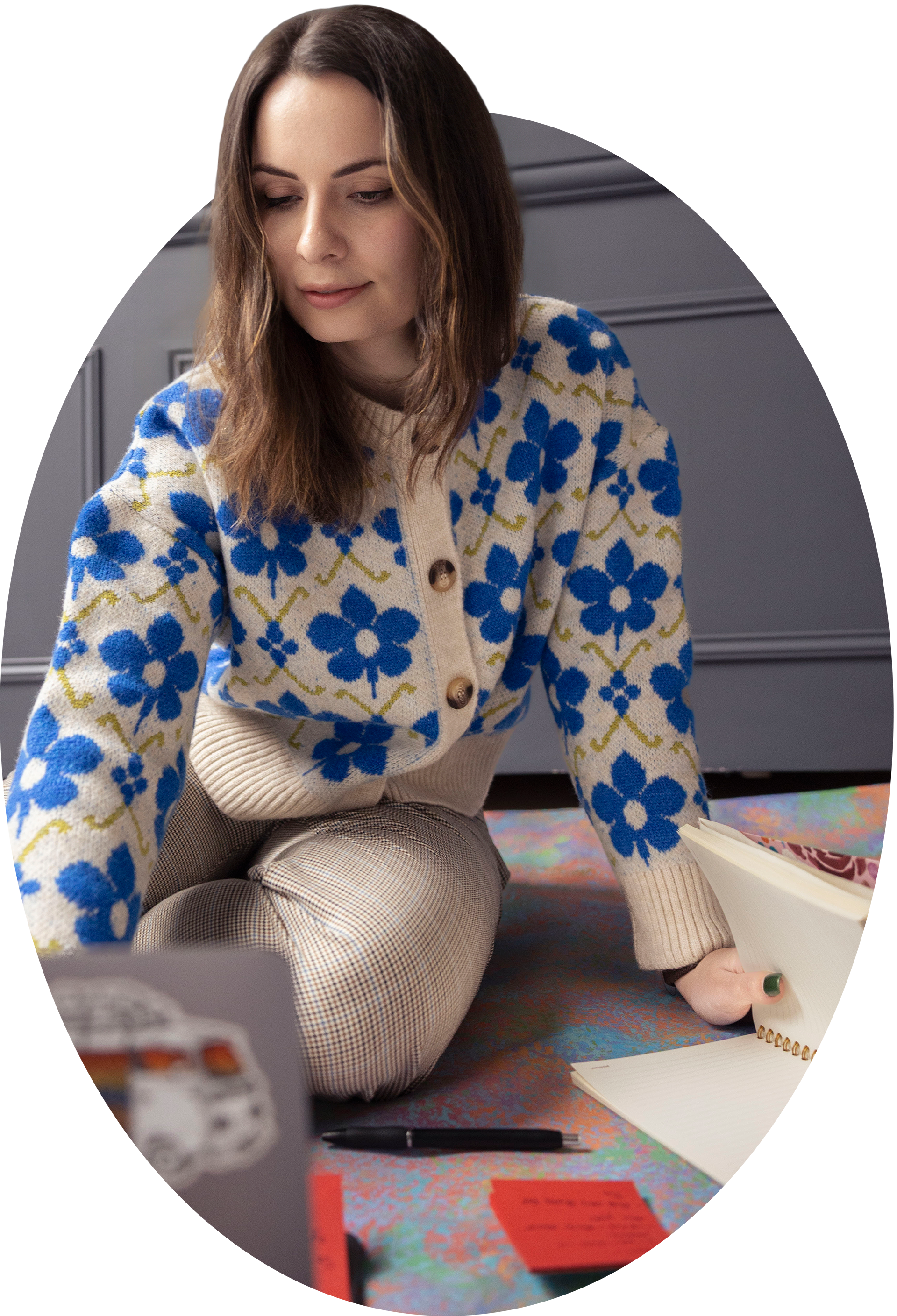 A picture of Olivia sitting on the ground with her laptop in full creative focus mode.