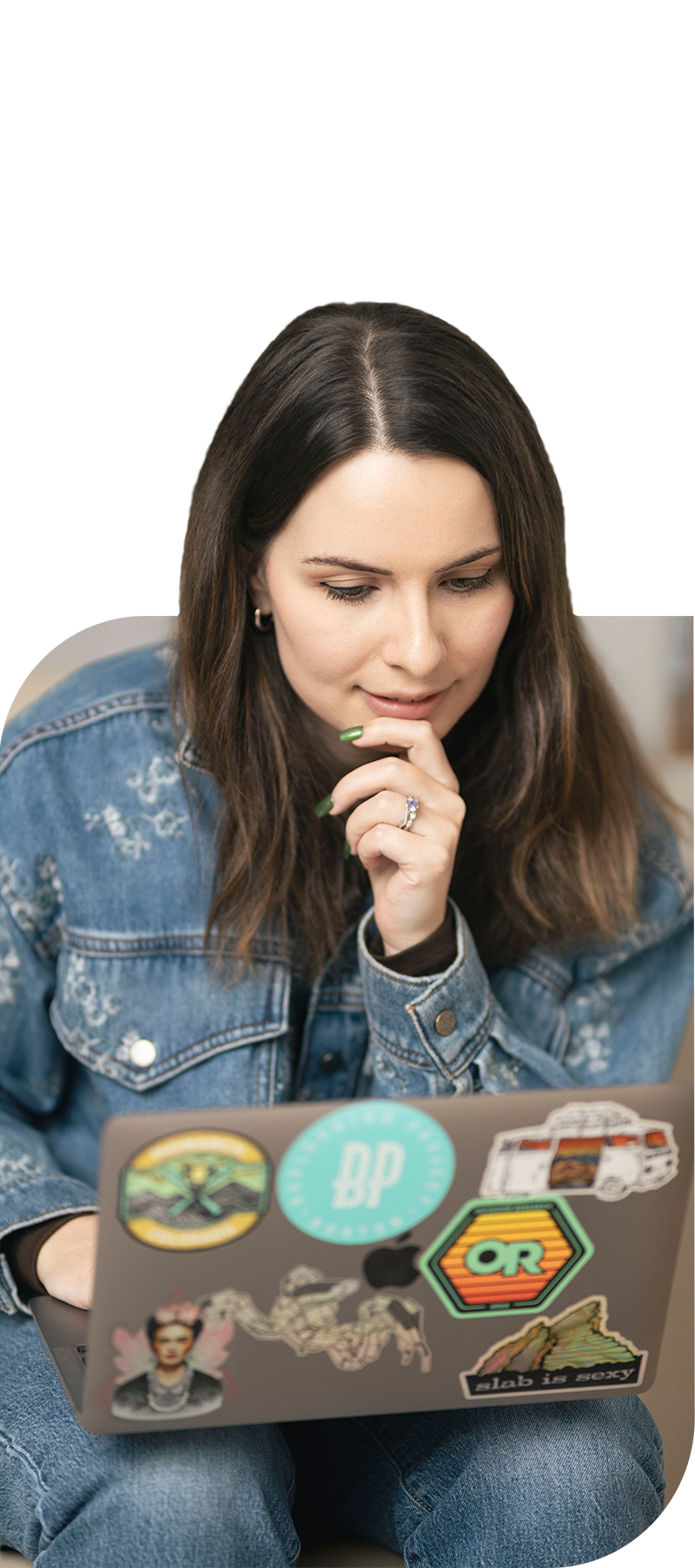A picture of Olivia thinking with her hand on her chin as she sits with her laptop open.
