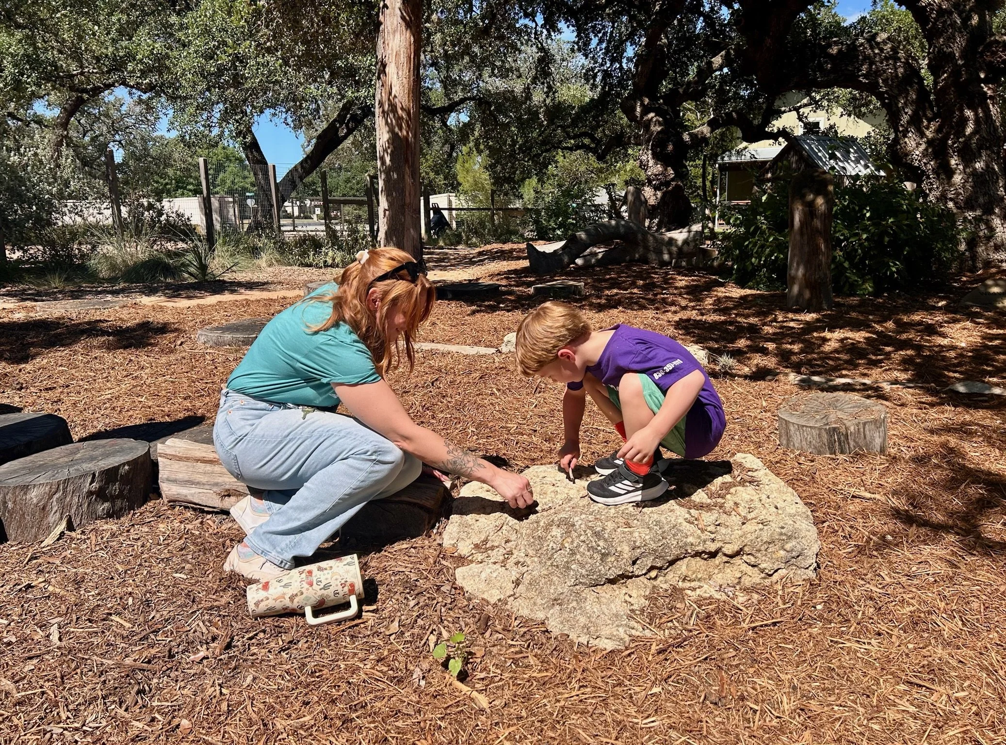 Nest Director Alysa Meeks and Nest Student looking at something on the playground