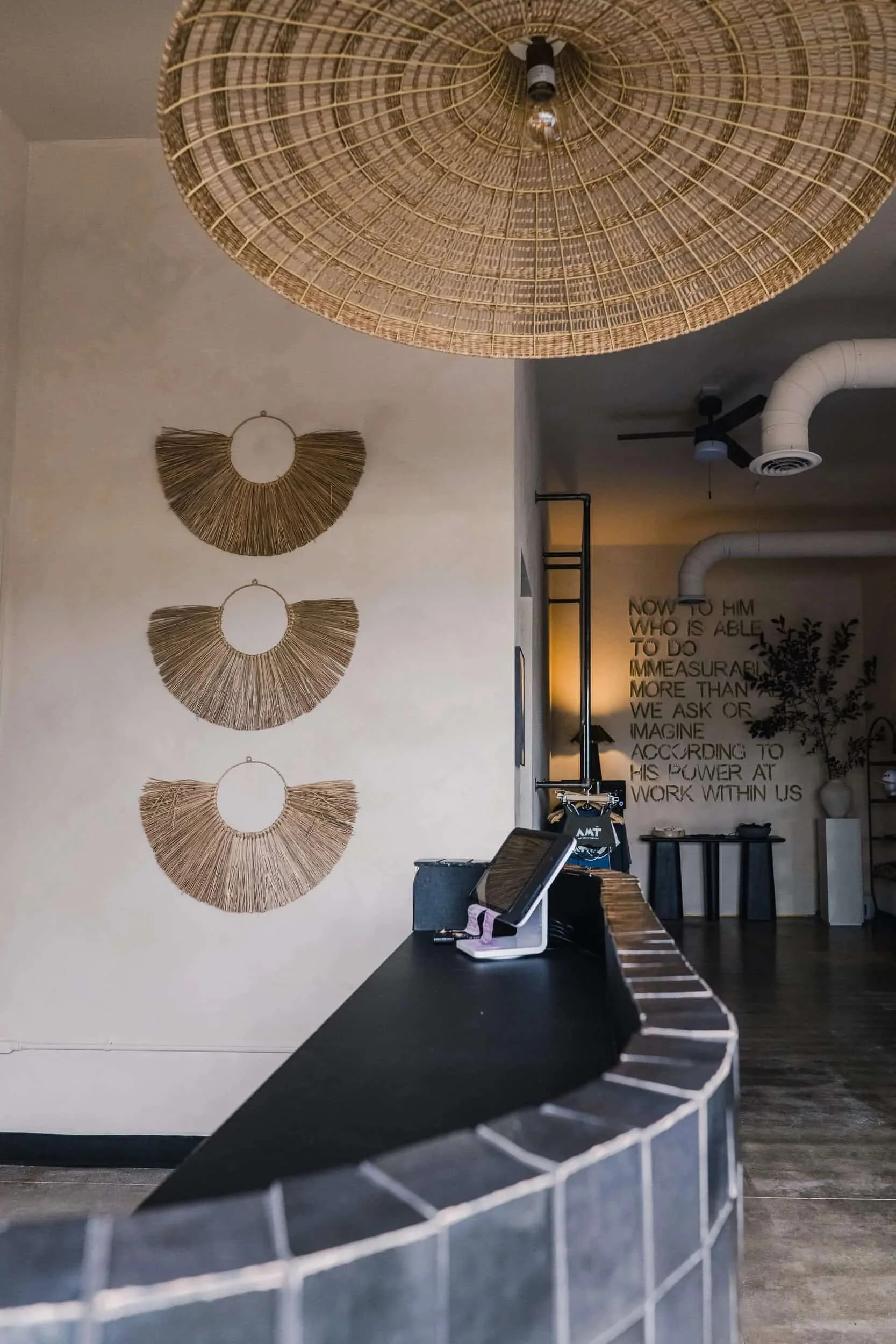 Close-up of the rattan chandelier and a trio of decorative, fan-shaped rattan wall hangings.