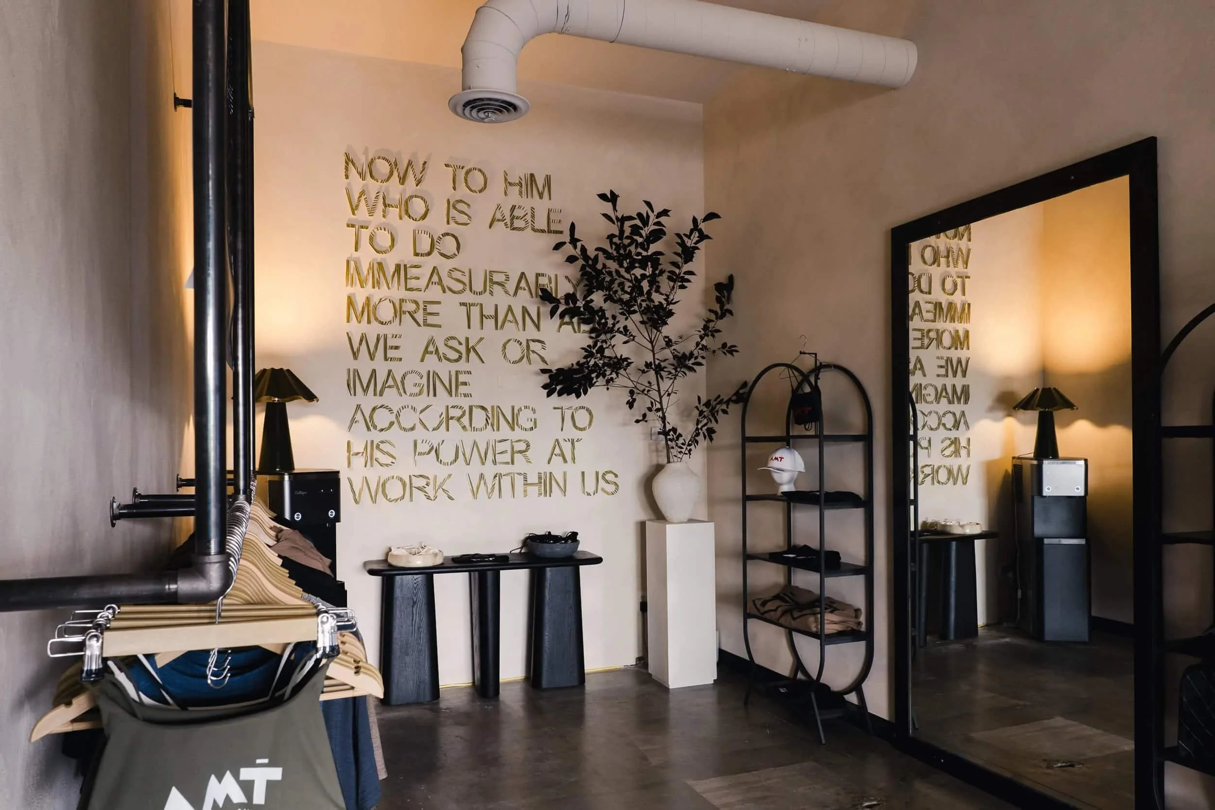 Long view of a dark counter or bar area in the open-concept space, with the motivational wall art faintly visible in the background