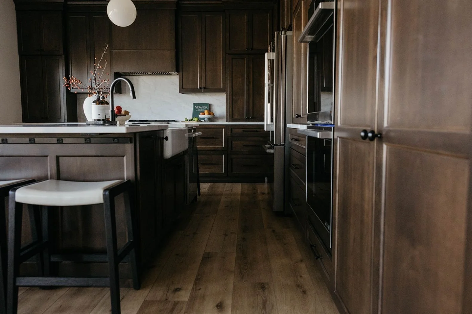 Close-up of the floor-to-ceiling dark wood kitchen cabinetry with subtle paneling and integrated hardware.