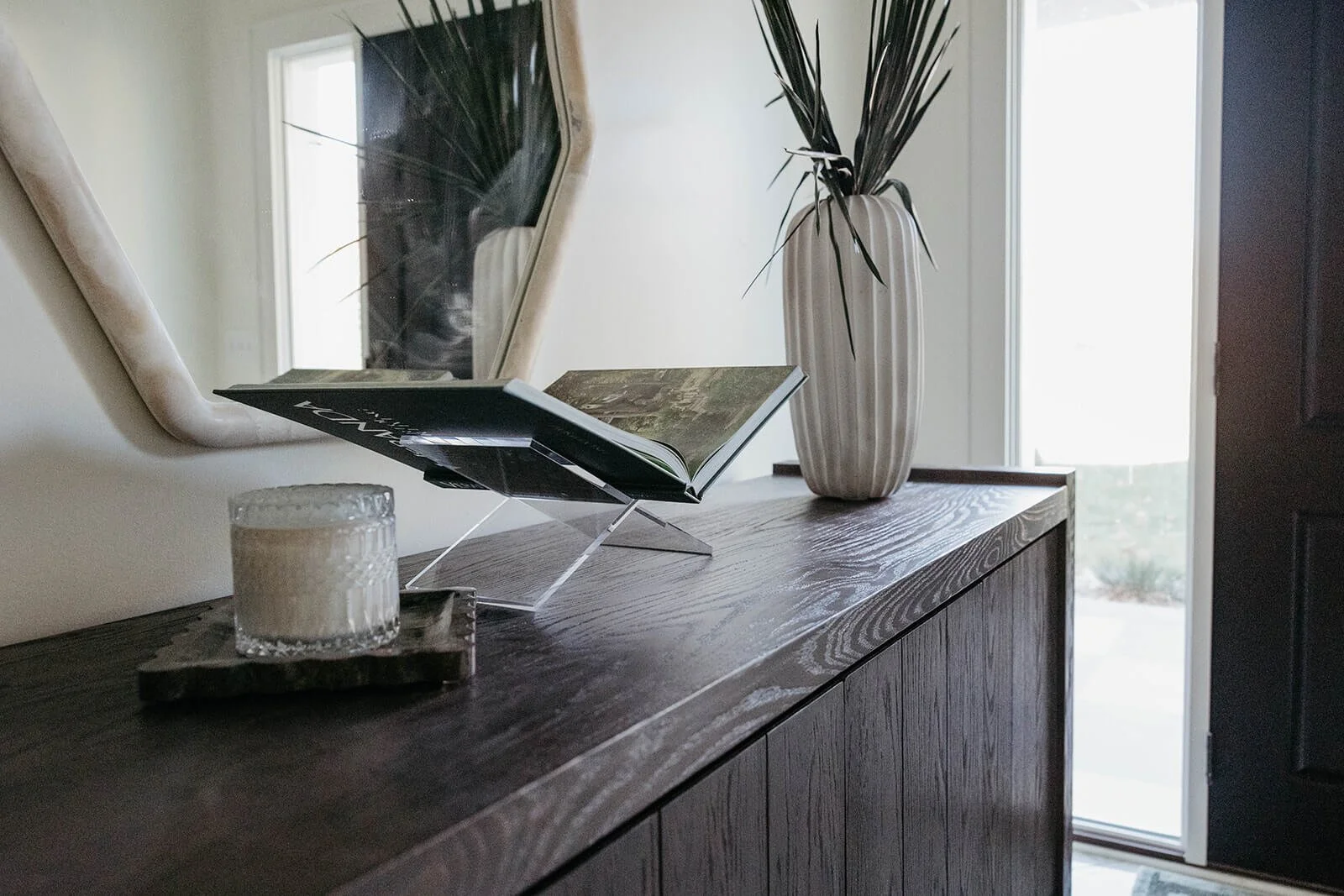 Close-up detail of the dark wood console cabinet showcasing its rich wood grain and the decorative styling elements.