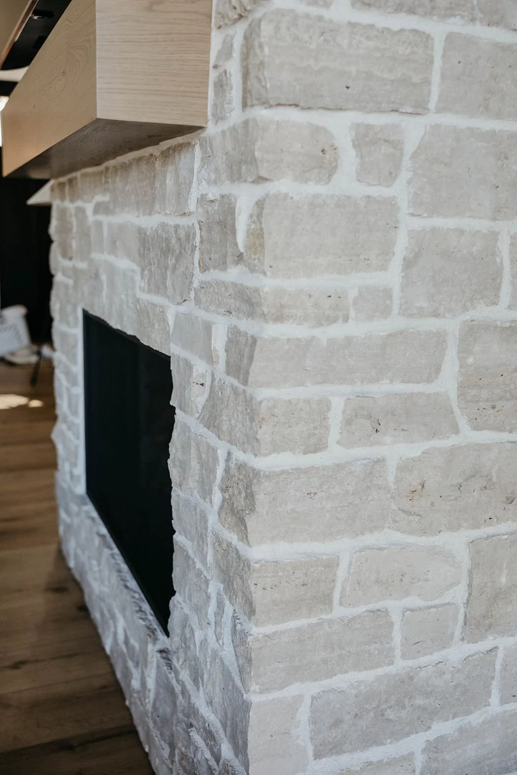 Close-up of the light, textured limestone or brick masonry of the fireplace surround.