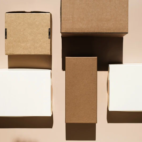 Various cardboard boxes arranged on a pink surface with shadows.