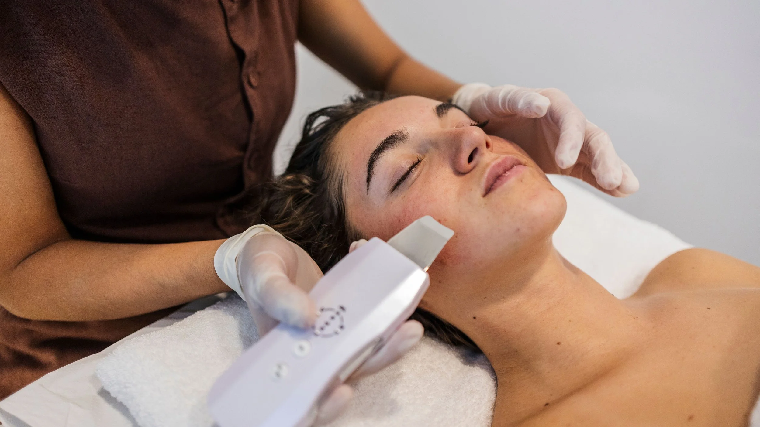 Esthetician performing a facial treatment on a client in a professional skincare studio