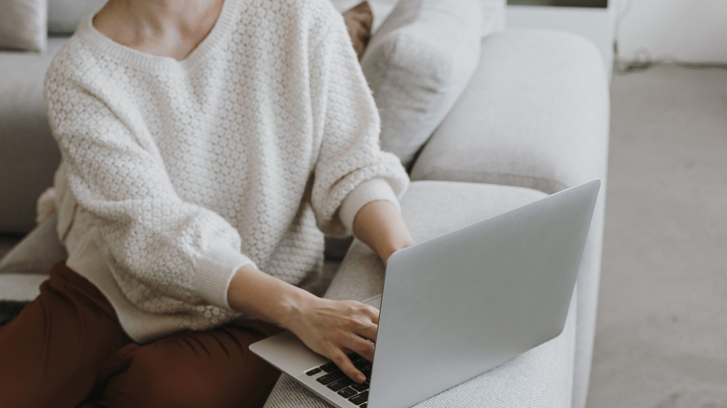 Woman browsing a website on a laptop for esthetician website optimization guide