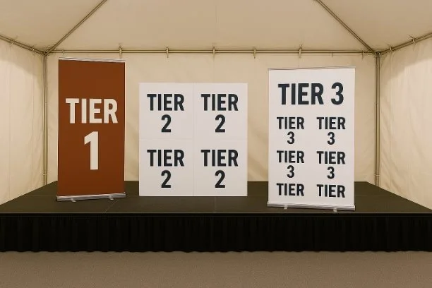 Display of three tier level signs labeled 'Tier 1', 'Tier 2', and 'Tier 3' in a tented area.