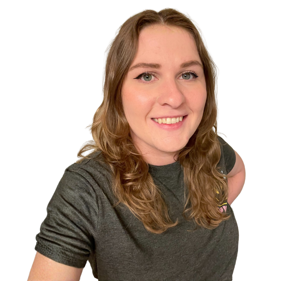 A young woman with long wavy light brown hair and green eyes smiling at the camera, wearing a dark gray T-shirt.