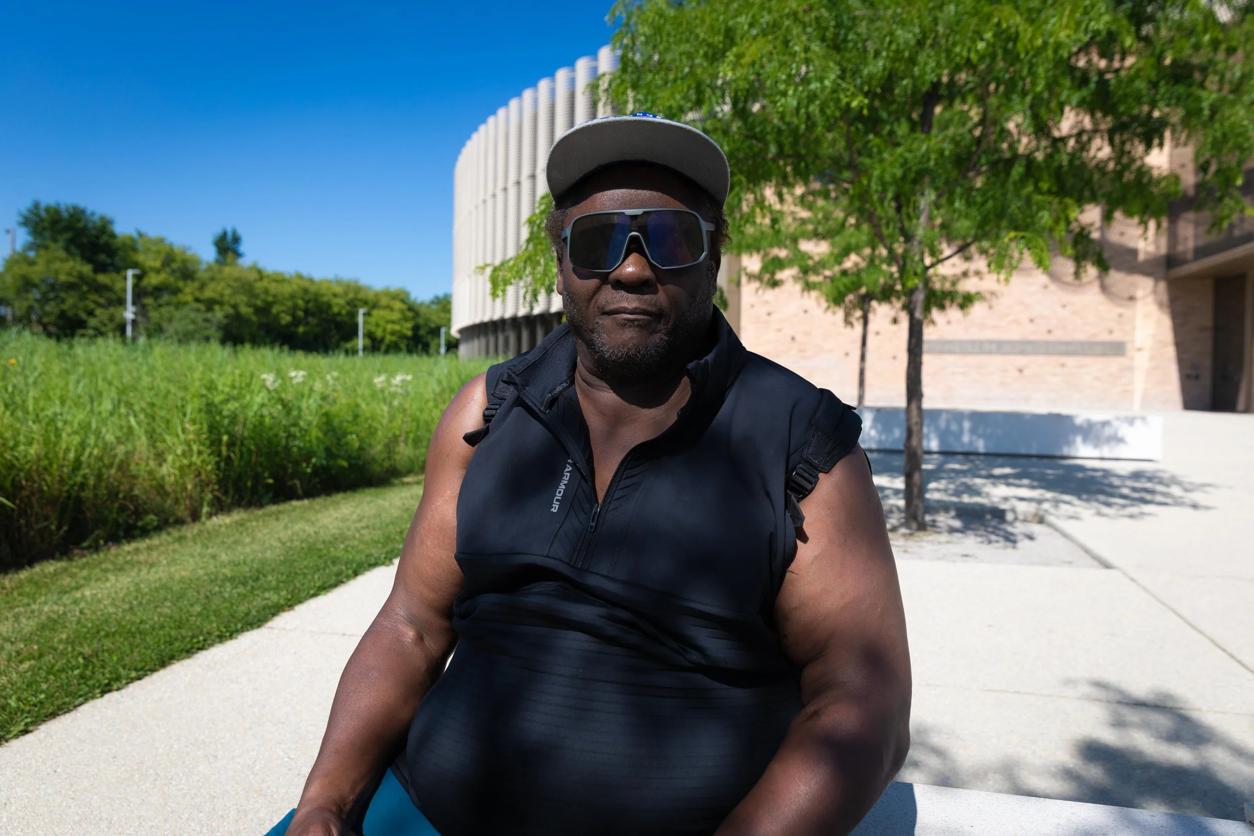 Larry Johnson relaxes in the shade on a concrete bench at the Brighton Park Community Campus on Thursday, June 25, 2026. Johnson frequently visits the campus, located on Chicago’s Southwest Side, to work out outdoors. This photo is part of the Columb
