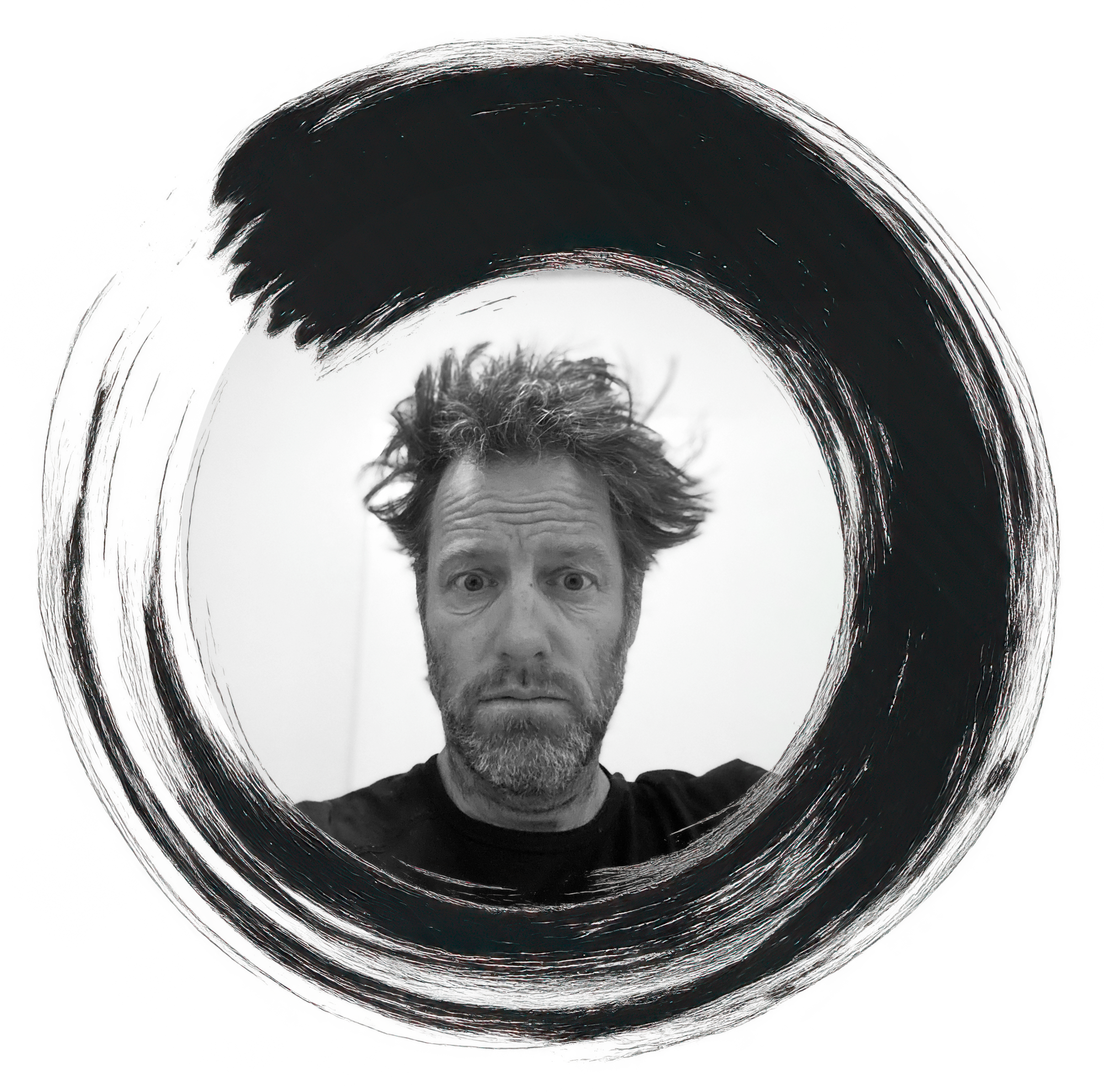 A black-and-white photo of a man with messy hair and a beard, looking directly at the camera with a confused or surprised expression. The photo is framed in a circular brushstroke style.