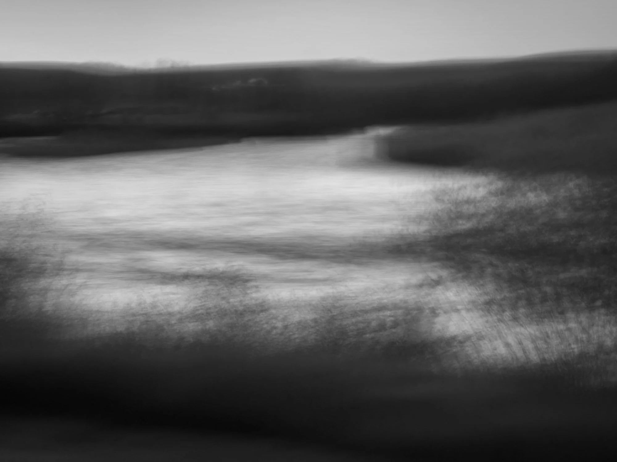 Abstract black and white photograph with blurred textures and lines.
