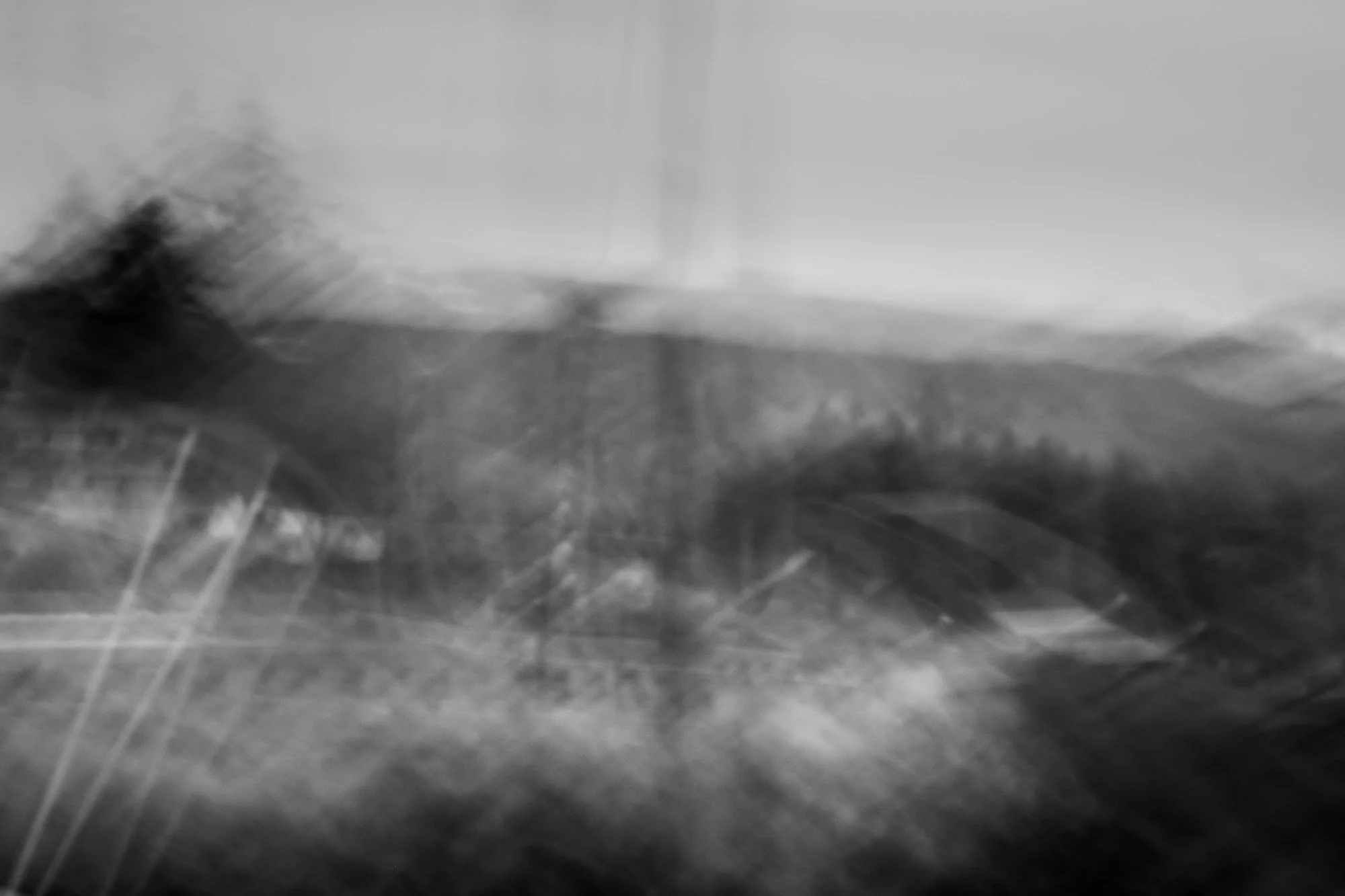 Abstract black and white blurred landscape image with streaks and smudges.