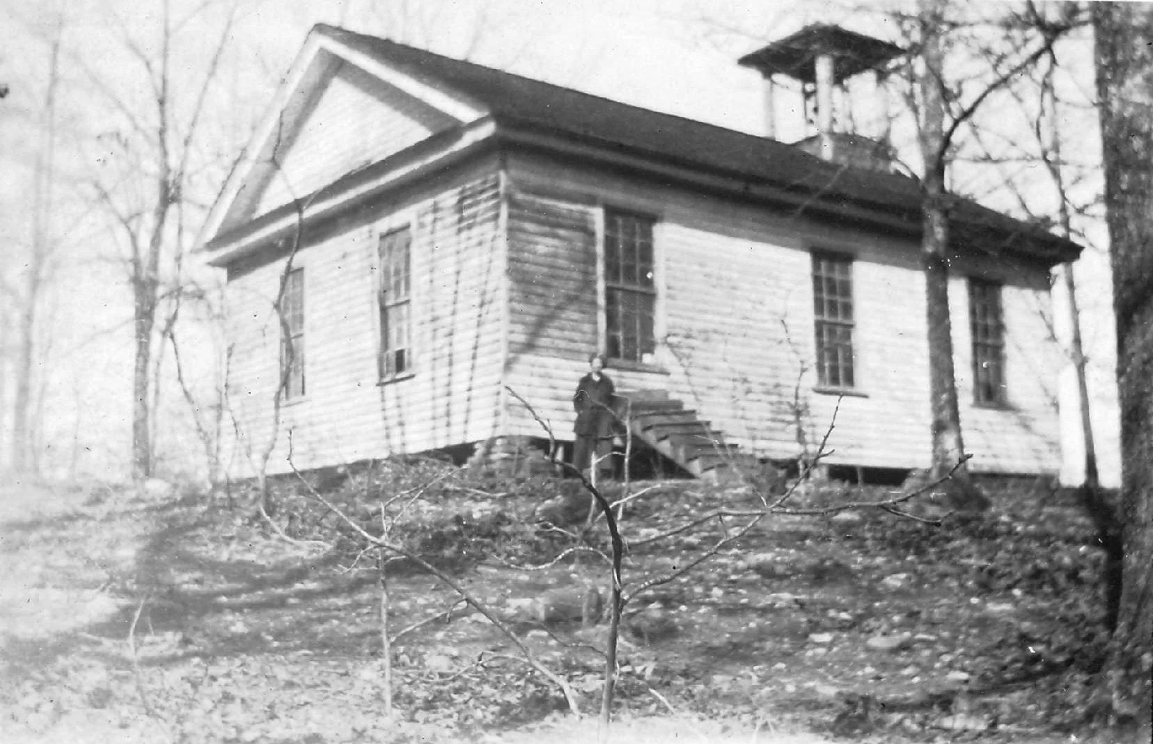 Augusta Tatum standing in front of McKee's Chapel in Dawson County GA in 1923. Black and white picture of woman standing in front of a chapel.