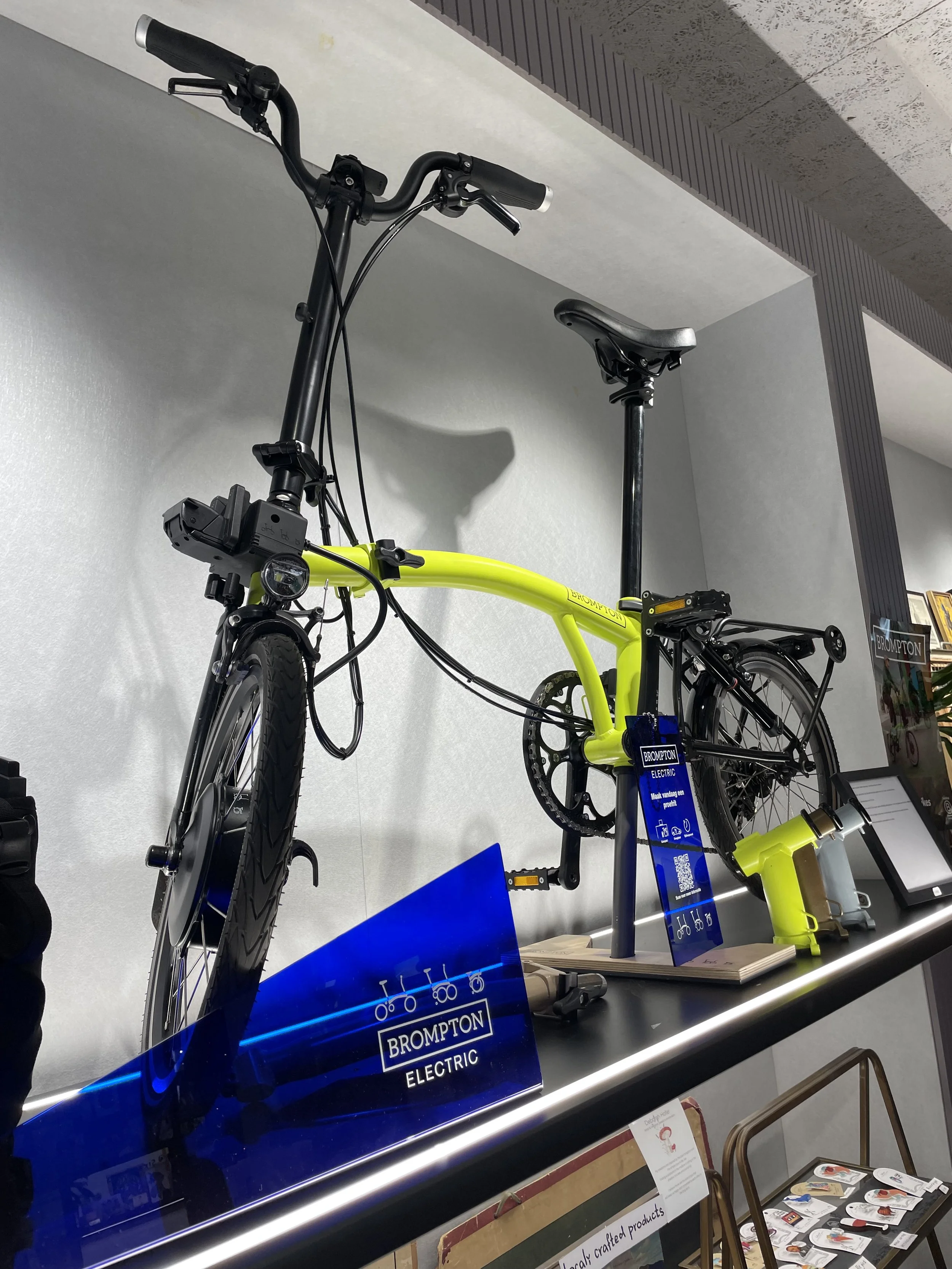 Urban mobility pop-up display featuring yellow Brompton bike — Amsterdam retail project by Nata Buro