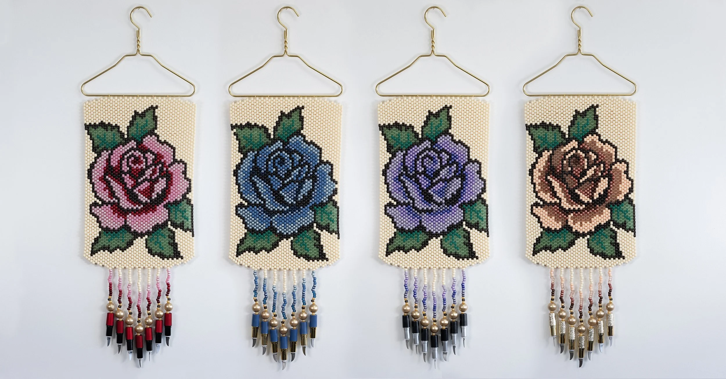 Four beaded wall hangings featuring colorful roses with green leaves, each hanging on a gold wire hanger. They have fringe made of beads and metallic beads at the bottom.