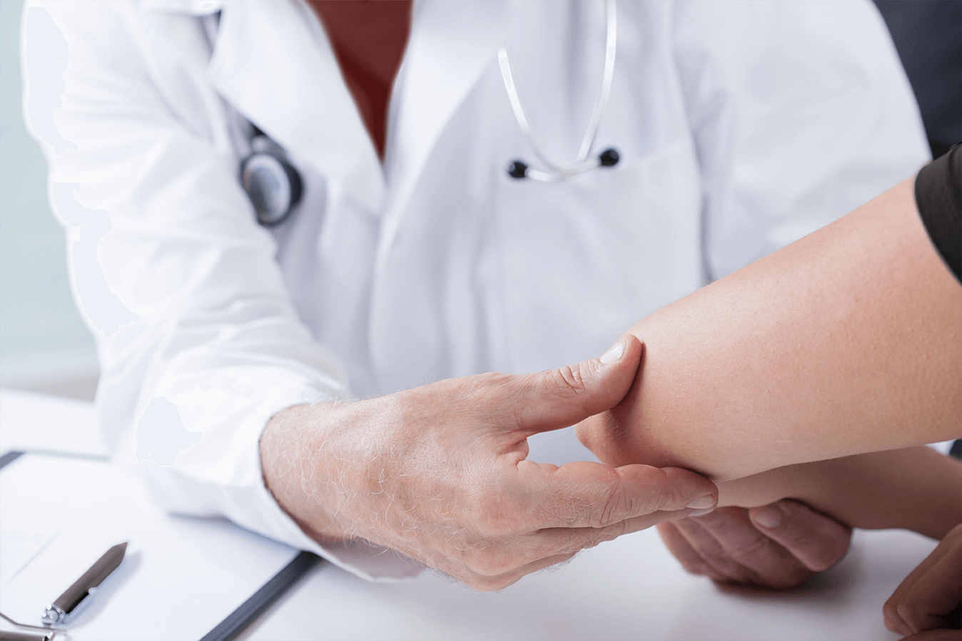 Doctor examining a patient's arm in a clinical setting.