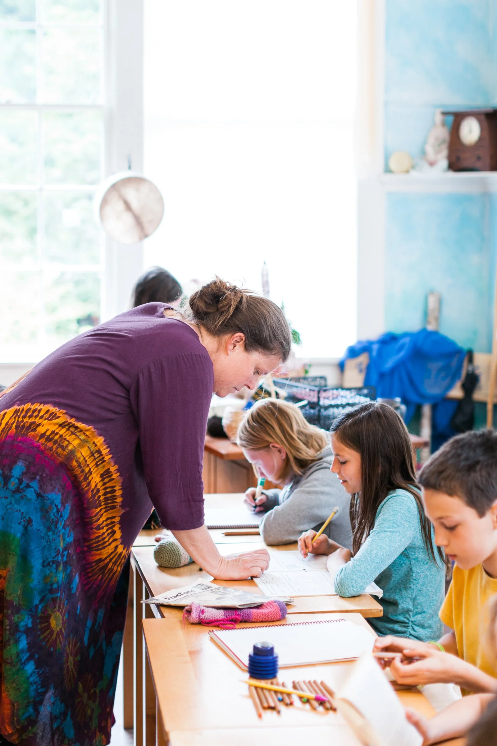 Teacher helping students at their desks