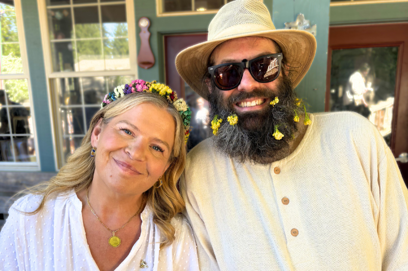 Community members smiling and wearing flowers