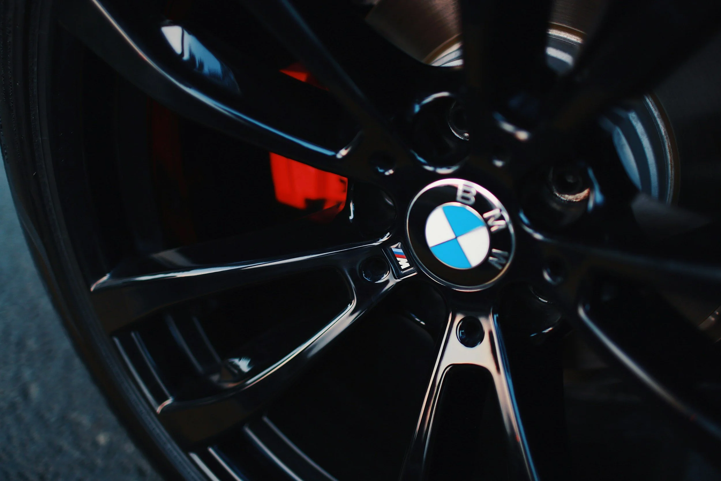 Close-up of a black BMW wheel with a silver logo in the center.