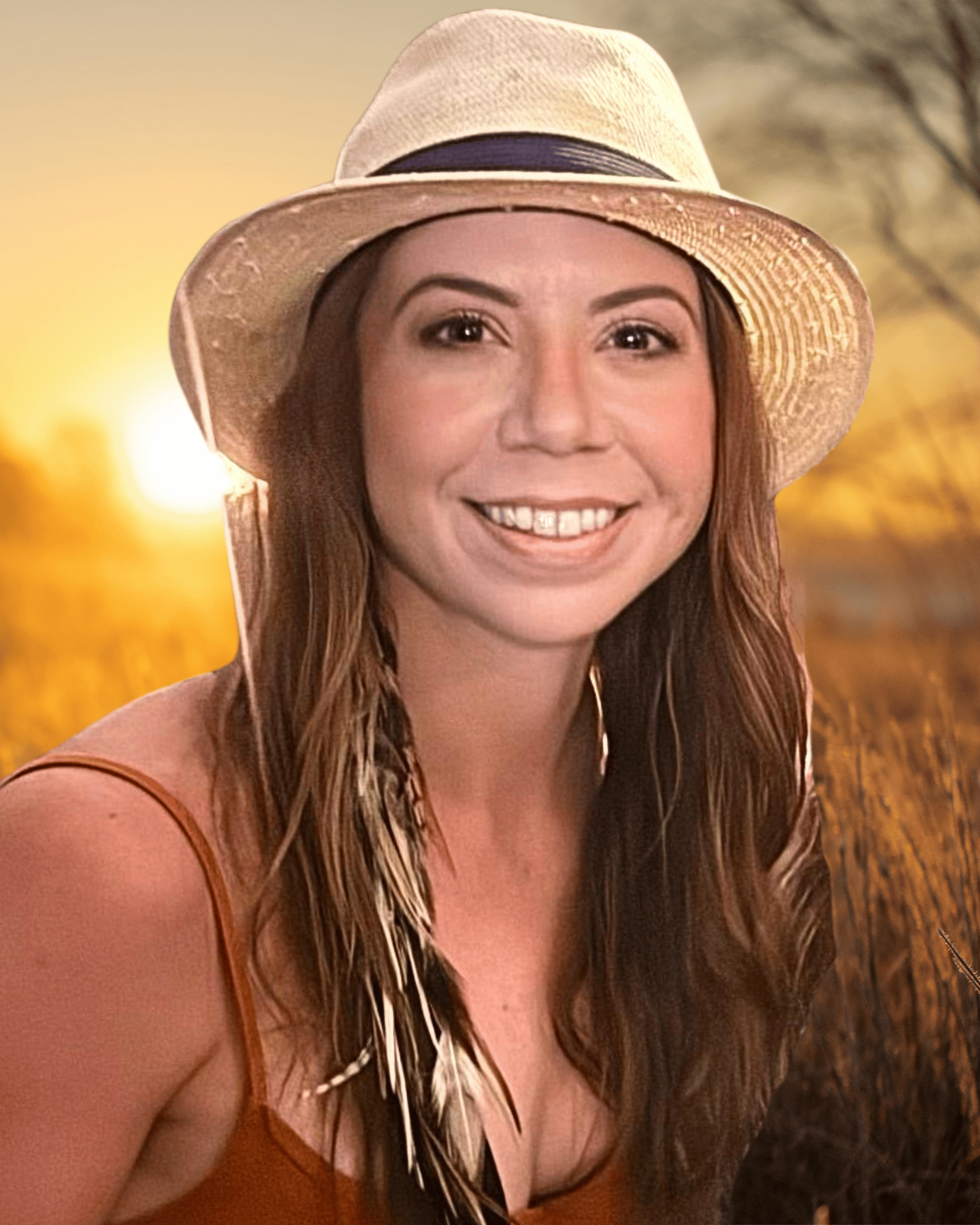 A woman with curly black hair, wearing glasses, earrings, and necklaces, smiling indoors.