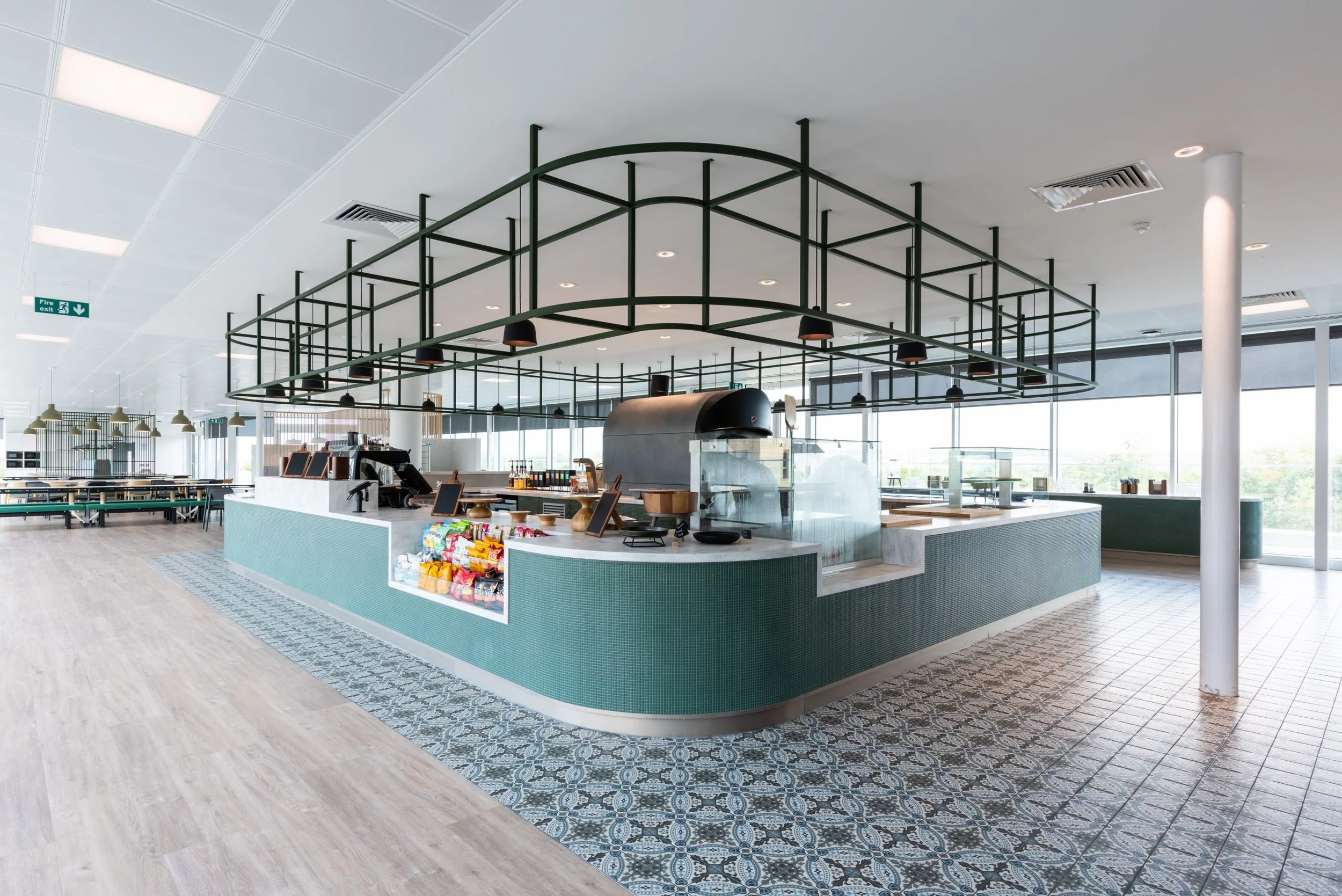 Modern cafe counter with snack and beverage supplies in a bright, open space.