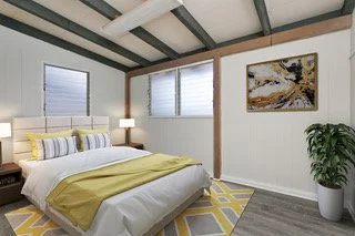 Bedroom with white walls, two windows with blinds, a bed with yellow and gray bedding, yellow and gray rug, abstract painting, and a potted plant.